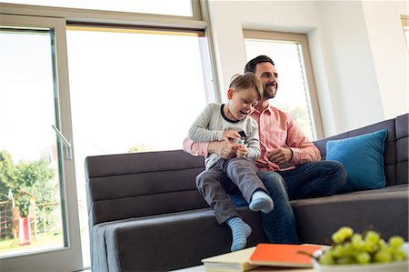 simsearch:6109-08536469,k - Father and son playing on the couch Stock Photo - Premium Royalty-Free, Code: 6109-08398811