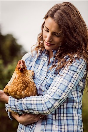 simsearch:6109-08399040,k - Woman holding and looking at chicken Foto de stock - Sin royalties Premium, Código: 6109-08399040