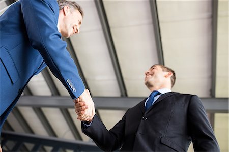 simsearch:6109-08690271,k - Two smiling businessmen shaking hands Fotografie stock - Premium Royalty-Free, Codice: 6109-08399187