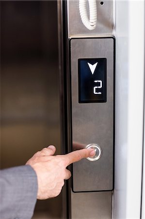 simsearch:6109-06781459,k - Close up view of businessman pressing elevators button Stock Photo - Premium Royalty-Free, Code: 6109-08399245