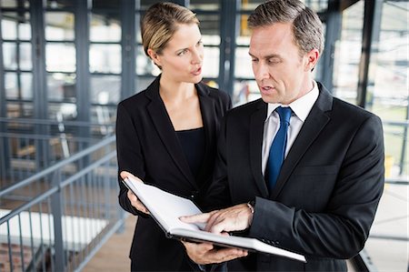 Business people discussing about a file Stock Photo - Premium Royalty-Free, Code: 6109-08399277