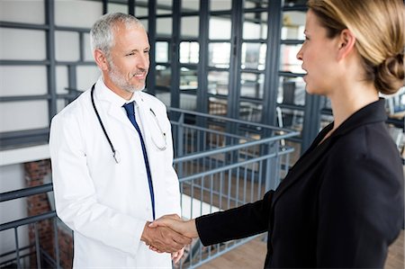 smiling blond woman in business suit - Businesswoman and doctor make a handshake Stock Photo - Premium Royalty-Free, Code: 6109-08399289