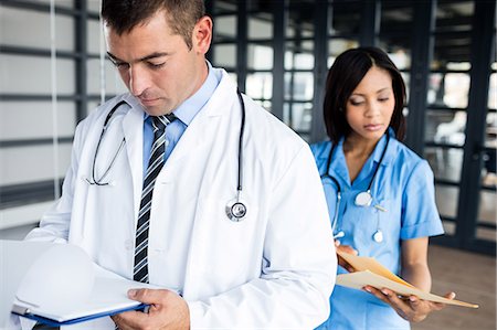 simsearch:6109-08399289,k - Nurse and doctor looking at files Stock Photo - Premium Royalty-Free, Code: 6109-08399296