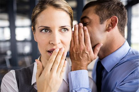 Businessman whispering something to his colleague Foto de stock - Royalty Free Premium, Número: 6109-08399206