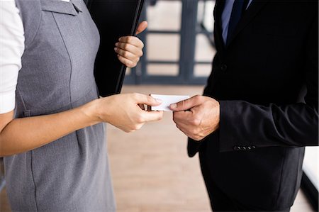 Businessman giving his business card to his colleague Stock Photo - Premium Royalty-Free, Code: 6109-08399208