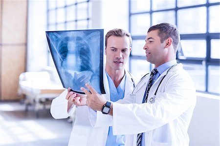 Medical team looking at x-ray together Foto de stock - Sin royalties Premium, Código: 6109-08399359