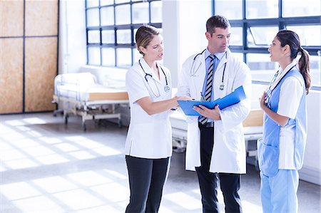 simsearch:400-03924532,k - Medical team discussing the report together Stock Photo - Premium Royalty-Free, Code: 6109-08399363