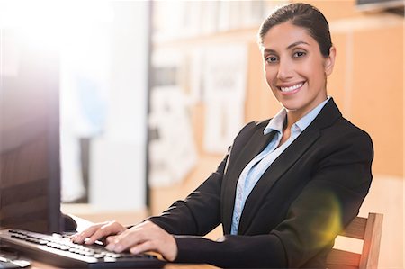 simsearch:6109-08399397,k - Smiling businesswoman typing on keyboard Stock Photo - Premium Royalty-Free, Code: 6109-08399391