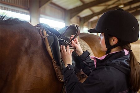 establo - Female rider fixing saddle Foto de stock - Sin royalties Premium, Código: 6109-08399484