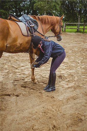 Female rider cleaning horseshoe Foto de stock - Sin royalties Premium, Código: 6109-08399522