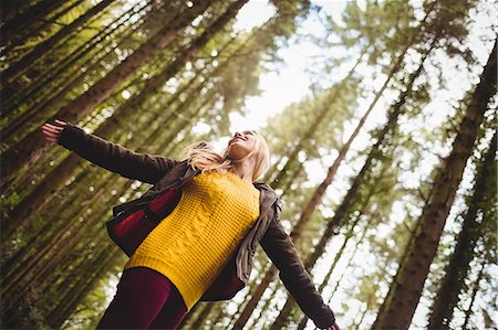 simsearch:6109-08435738,k - Beautiful blonde woman with arms outstretched in the woods Photographie de stock - Premium Libres de Droits, Code: 6109-08481685