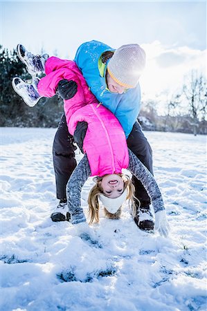 simsearch:6109-08481777,k - Father carrying his daughter who is overhead on a beautiful snowy day Foto de stock - Royalty Free Premium, Número: 6109-08481785