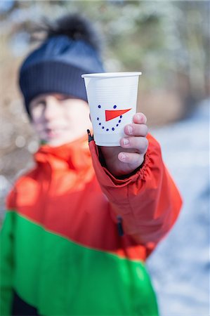 Cute boy showing cup on a beautiful snowy day Stock Photo - Premium Royalty-Free, Code: 6109-08481735