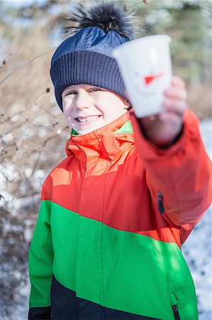 Cute boy showing cup on a beautiful snowy day Stock Photo - Premium Royalty-Free, Code: 6109-08481736