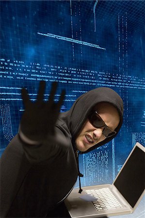 sous couverture - Hacker using laptop to steal data Photographie de stock - Premium Libres de Droits, Code: 6109-08481861