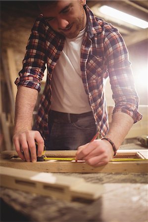 segatura - Carpenter working on his craft in a dusty workshop Fotografie stock - Premium Royalty-Free, Codice: 6109-08481881