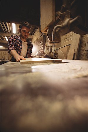 simsearch:6109-08481880,k - Carpenter working on his craft in a dusty workshop Photographie de stock - Premium Libres de Droits, Code: 6109-08481897