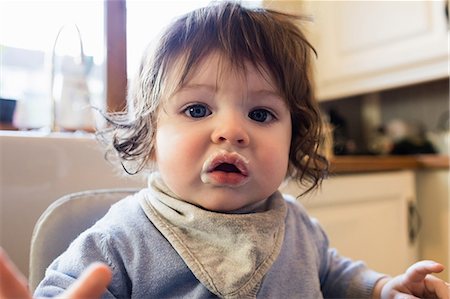 simsearch:6109-08488688,k - Cute baby with food on his mouth in the kitchen Stock Photo - Premium Royalty-Free, Code: 6109-08481805