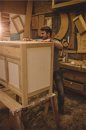 Carpenter working on his craft in a dusty workshop Stock Photo - Premium Royalty-Free, Code: 6109-08481954