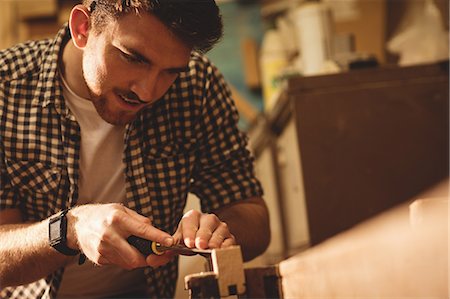 simsearch:6109-08481912,k - Carpenter working on his craft in a dusty workshop Foto de stock - Sin royalties Premium, Código: 6109-08481963