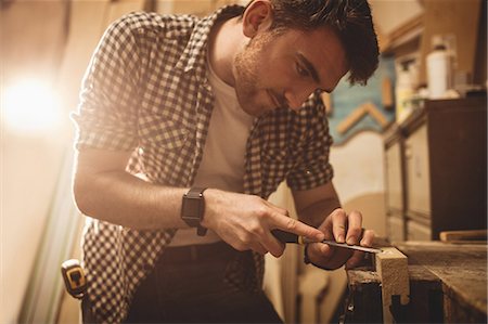Carpenter working on his craft in a dusty workshop Foto de stock - Sin royalties Premium, Código: 6109-08481960