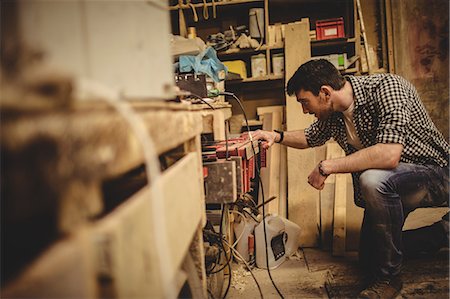 simsearch:6109-08689682,k - Carpenter working on his craft in a dusty workshop Stock Photo - Premium Royalty-Free, Code: 6109-08481979
