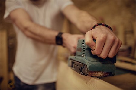 simsearch:6109-08481890,k - Carpenter working on his craft in a dusty workshop Photographie de stock - Premium Libres de Droits, Code: 6109-08481992