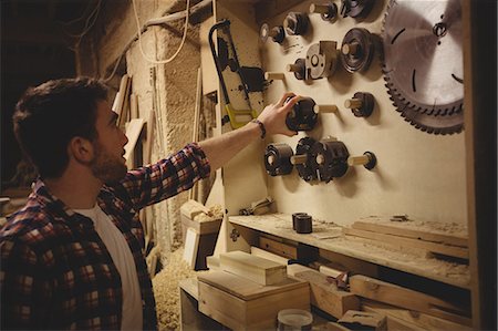 simsearch:6109-08481900,k - Carpenter working on his craftin a dusty workshop Foto de stock - Sin royalties Premium, Código: 6109-08481900