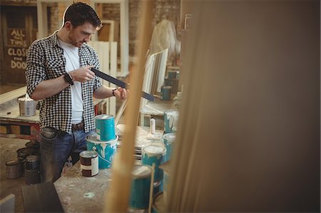 simsearch:6109-08481994,k - Carpenter working on his craft in a dusty workshop Photographie de stock - Premium Libres de Droits, Code: 6109-08481926