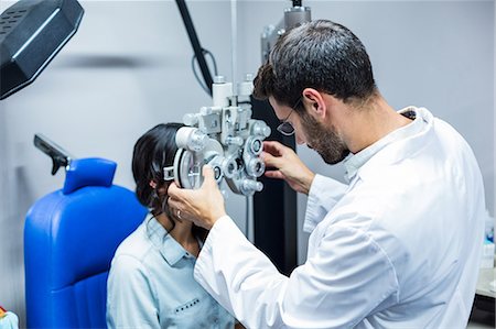 phoromètre - Optician using a phoropter on his patient in a clinic Photographie de stock - Premium Libres de Droits, Code: 6109-08488650