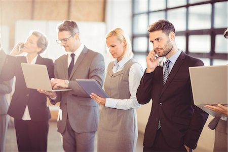 suit yelling - Business team using their media devices at the office Stock Photo - Premium Royalty-Free, Code: 6109-08488760