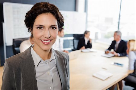 simsearch:6109-08488781,k - Businesswoman smiling at the camera during meeting at the office Stock Photo - Premium Royalty-Free, Code: 6109-08488789