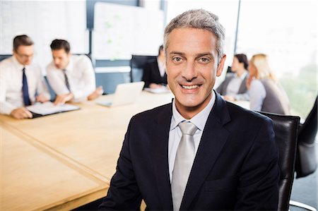 simsearch:6109-08394968,k - Businessman smiling at the camera during meeting at the office Stock Photo - Premium Royalty-Free, Code: 6109-08488790