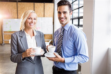 simsearch:6109-08489682,k - Business partners smiling over coffee at the office Fotografie stock - Premium Royalty-Free, Codice: 6109-08488857