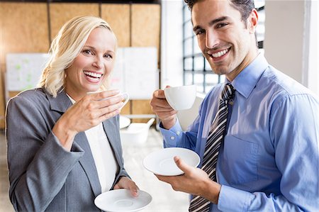 simsearch:6109-08489682,k - Business partners smiling over coffee at the office Fotografie stock - Premium Royalty-Free, Codice: 6109-08488858