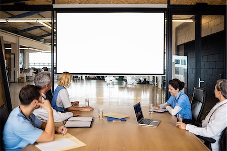 Business team using video chat during meeting at the office Stock Photo - Premium Royalty-Free, Code: 6109-08488859