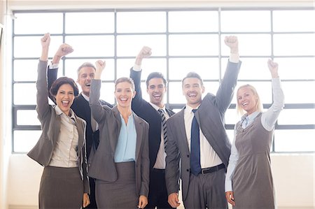 simsearch:6109-06002803,k - Business team cheering at the camera at the office Stock Photo - Premium Royalty-Free, Code: 6109-08488811
