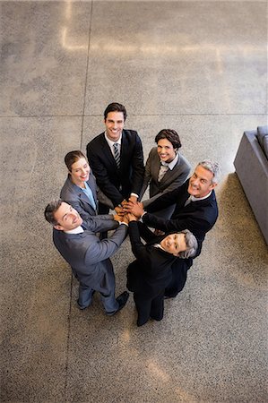 simsearch:6109-08488781,k - Business team putting their hands together at the office Stock Photo - Premium Royalty-Free, Code: 6109-08488819