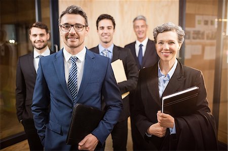 simsearch:6109-08488781,k - Business team smiling at the camera at the office Stock Photo - Premium Royalty-Free, Code: 6109-08488824
