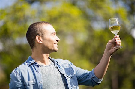 simsearch:614-06973691,k - Smiling man looking at a glass of white wine in garden Stock Photo - Premium Royalty-Free, Code: 6109-08488967