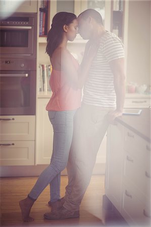 simsearch:6109-08489084,k - Love couple kissing in the kitchen at home Photographie de stock - Premium Libres de Droits, Code: 6109-08489049