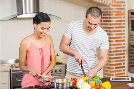 simsearch:400-06891385,k - Smiling couple preparing vegetables in the kitchen at home Stock Photo - Premium Royalty-Free, Code: 6109-08489051