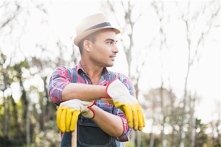 farmer with overalls - Gardener man posing with his rake in the garden Stock Photo - Premium Royalty-Free, Code: 6109-08489083