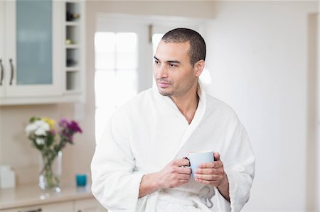 Thoughtful man in bath robe drinking coffee at home Foto de stock - Sin royalties Premium, Código: 6109-08489025