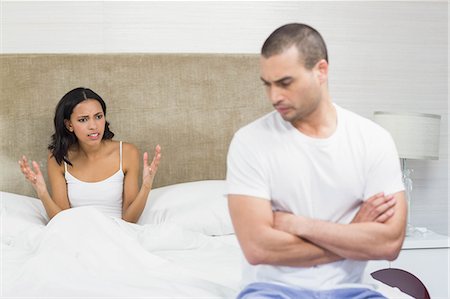 simsearch:6109-08536960,k - Upset couple sitting on bed after having an argument at home Foto de stock - Sin royalties Premium, Código: 6109-08489171