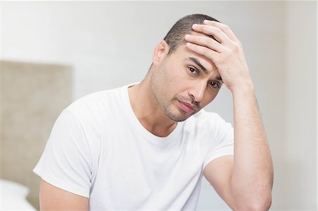 simsearch:6109-08489796,k - Upset man sitting on bed after having an argument at home Photographie de stock - Premium Libres de Droits, Code: 6109-08489182