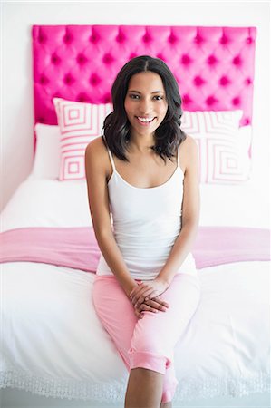 simsearch:400-07834992,k - Brunette smiling sitting on a bed in a pink room at home Fotografie stock - Premium Royalty-Free, Codice: 6109-08489185