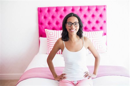 simsearch:400-07834992,k - Brunette smiling sitting on a bed in a pink room at home Fotografie stock - Premium Royalty-Free, Codice: 6109-08489189