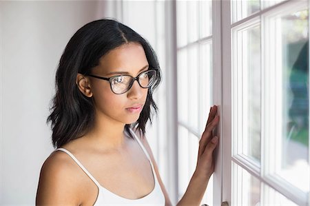 simsearch:6109-08390353,k - Thoughtful brunette looking through window in bedroom Stock Photo - Premium Royalty-Free, Code: 6109-08489199