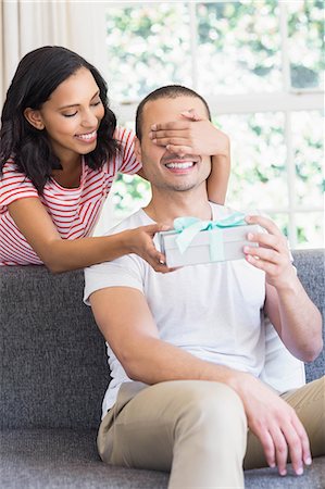 simsearch:6109-08489084,k - Happy couple offering gift while eye covered on the couch at home Photographie de stock - Premium Libres de Droits, Code: 6109-08489102